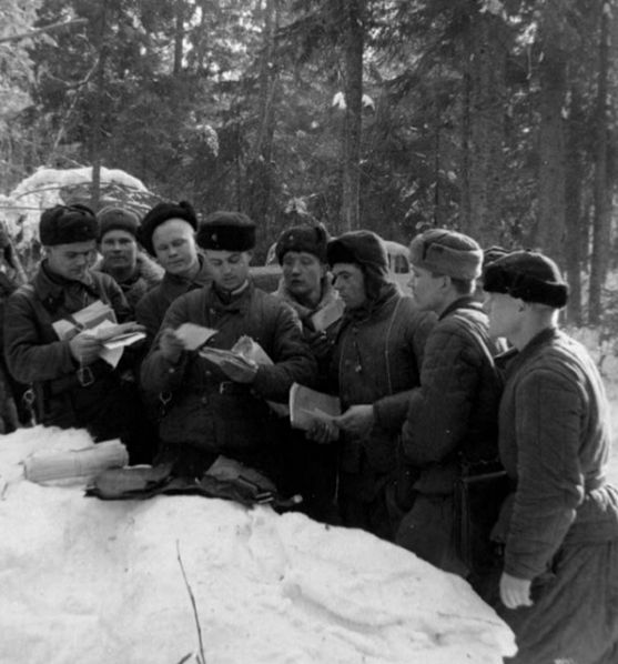 Фотография солдат на фронте, читающих письма из дома