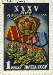 Значок ВЛКСМ на фоне орденов-наград комсомола