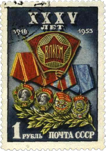 Значок ВЛКСМ на фоне орденов-наград комсомола